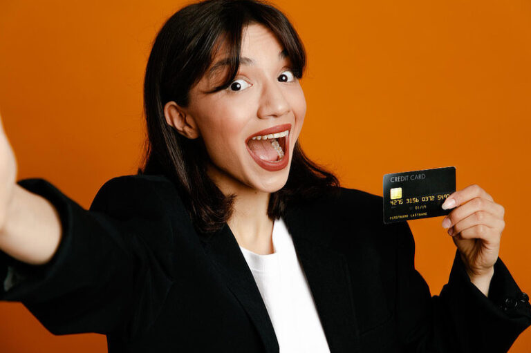 Surprised holding camera with card young beautiful female.