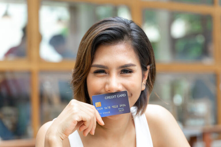 Cheerful young pretty woman used credit card.