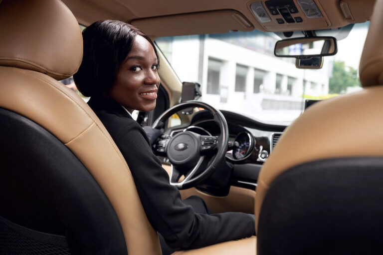 Female taxi driver looking in the back of the car.