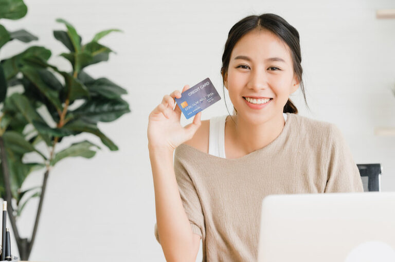 Asian woman showing credit card.