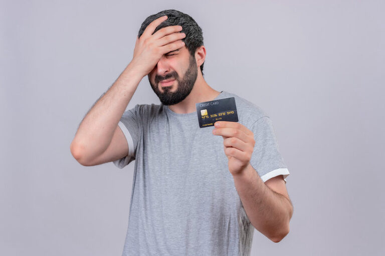 Stressed young man holding credit card.