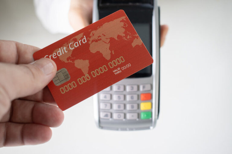 Person holding a red credit card.