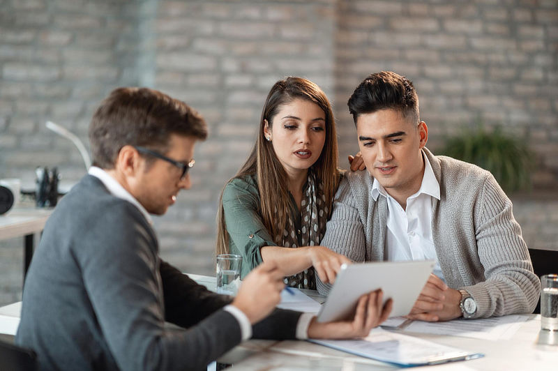 Couple using touchpad with financial advisor.